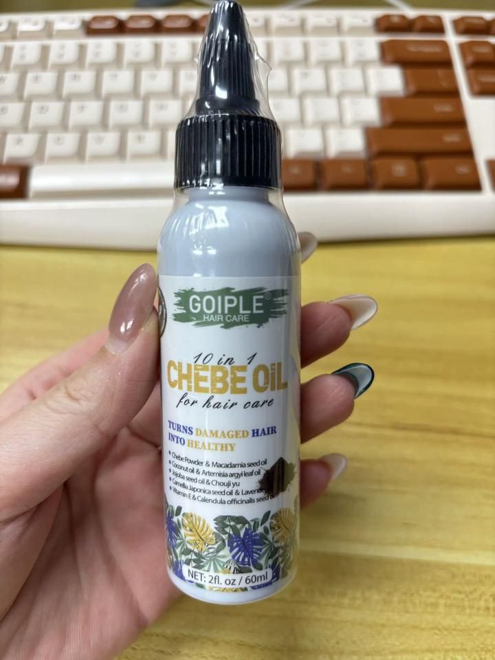 Goiple 10 in 1 Chebe Oil, 60ml, held in hand